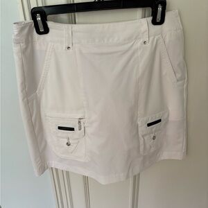 Jamie Sadock white golf skort with black piping.